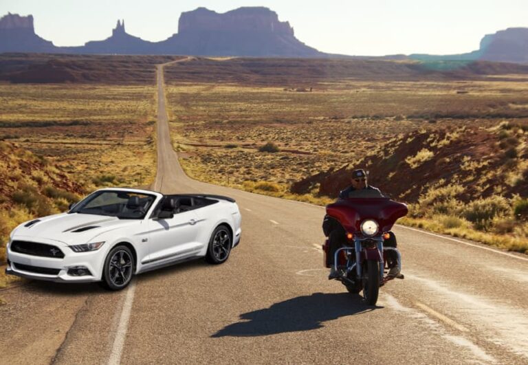 Une Mustang Cabriolet et une Harley sur une route de Monument Valley